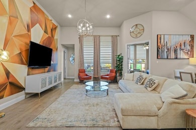 Living area with wood finished floors, recessed lighting, and a chandelier