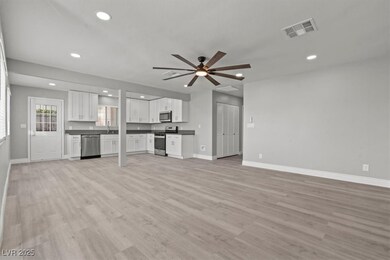 Unfurnished living room featuring a sink, baseboar