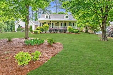Cape cod home featuring covered porch, a front yar