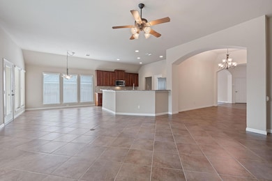 Unfurnished living room with arched walkways, lig