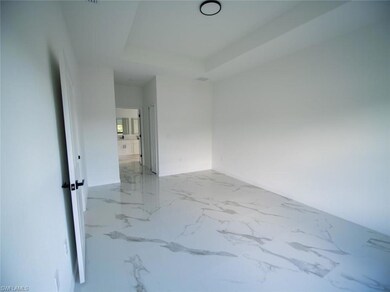 Master bedroom featuring light marble finish flooring and a raised ceiling