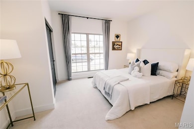 Bedroom featuring light colored carpet and baseboards