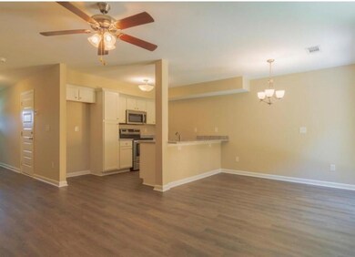 Unfurnished living room with dark wood finished floors, a ceiling fan, and a chandelier