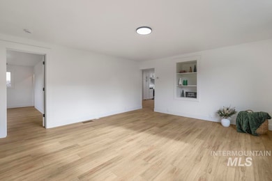 Unfurnished room featuring built in features and light wood finished floors