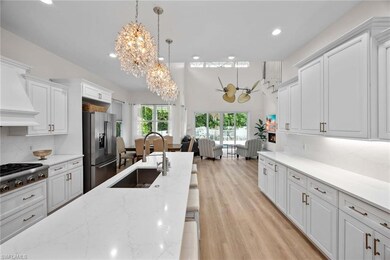 Kitchen featuring a chandelier, appliances with stainless steel finishes, a sink, recessed lighting, and white cabinets