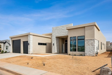Contemporary home with concrete driveway, stone siding, and stucco siding