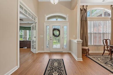 Entryway featuring wood finished floors, healthy amount of natural light, baseboards, and a high ceiling