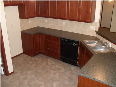 Another view of the kitchen with dark cabinetry