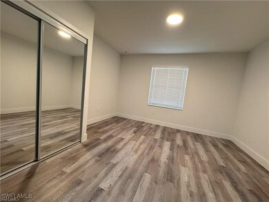 Unfurnished bedroom with wood finished floors, a c