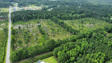 Aerial view of property and surrounding area featuring a forest
