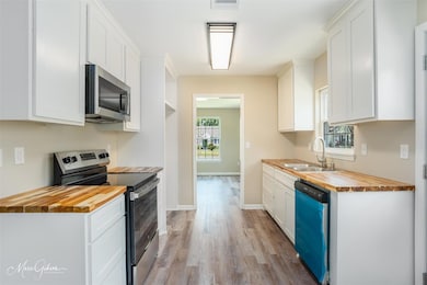 Kitchen featuring sink, butcher block counters, pl