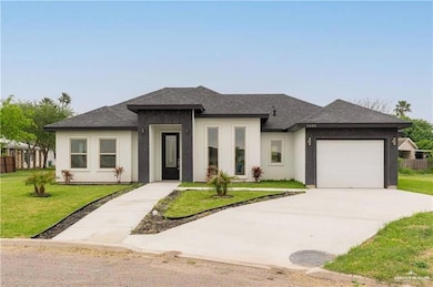 Prairie-style home with roof with shingles, an attached garage, a front lawn, concrete driveway, and stucco siding