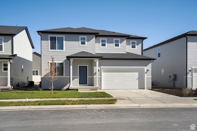 View of front of house with concrete driveway, an attached garage, and roof with shingles