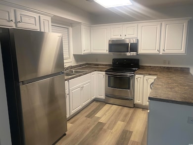Kitchen with light wood-style flooring, a sink, wh