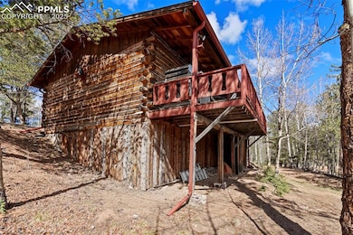 Rear view of property with log exterior and a wood