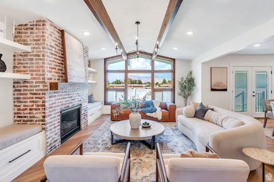 Great room with vaulted ceilings, false beams, fireplace, and huge windows