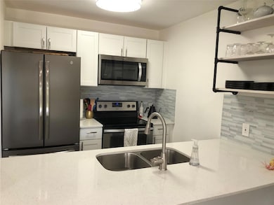 Kitchen featuring light stone countertops, white 