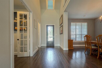 Sunlight pours through a glass front door, illuminating the welcoming foyer.