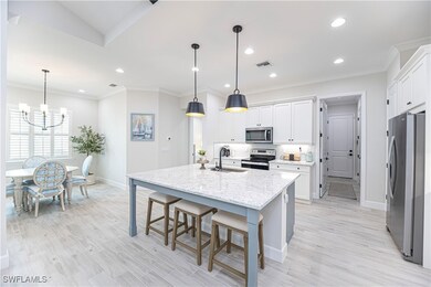 Kitchen with hanging light fixtures, an island wit