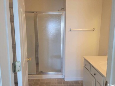 Bathroom with a shower stall, vanity, and baseboar