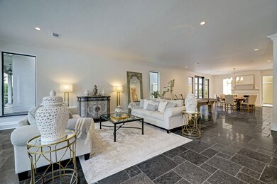 This open living room area seamlessly blends together the kitchen and dining spaces, creating a bright and airy atmosphere that's perfect for relaxing and entertaining