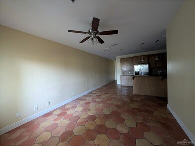 Unfurnished living room featuring a ceiling fan and baseboards