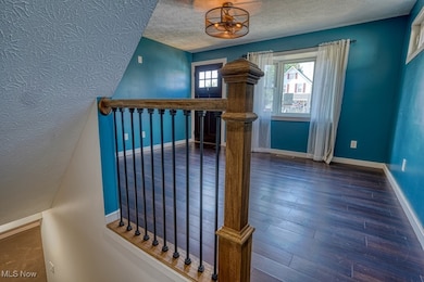 Stairs featuring a textured ceiling and wood finished floors