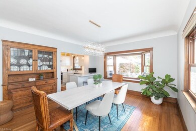 Dining room with built-in leaded glass cabinet, bay window, all open to kitchen.