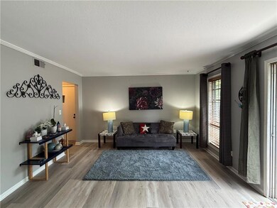 Living area featuring wood finished floors, ornamental molding, and baseboards