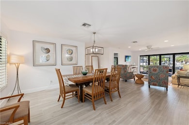 Dining room with ceiling fan with notable chandeli