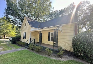 View of property exterior featuring a porch, stone siding, and a lawn