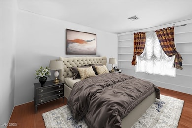 Bedroom with wood finished floors and baseboards