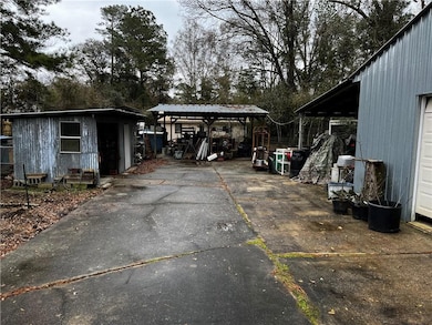 Loads of storage & hard surfaces. Southside. Shed on the left with electricity. Double carport/storage in the rear. Large workshop on the right side with electricity.