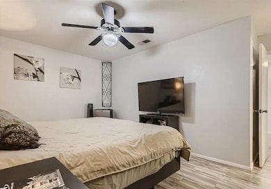Bedroom with light wood-type flooring and a ceiling fan