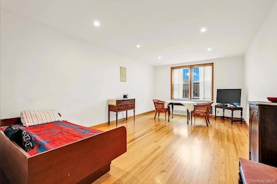 Bedroom with light wood-style flooring, recessed lighting, and radiator heating unit
