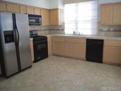 The sunny kitchen features stone tiled counters an