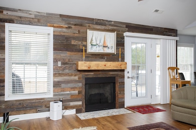 Living room with visible vents, a fireplace with f