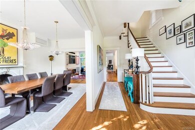 What a grand and welcoming foyer. Front staircase and view to the back den on your right. Gracious front parlor dining room on your left with marble fireplace.  Beautiful art chandeliers convey. Make it your dining room or living space. Your choice!