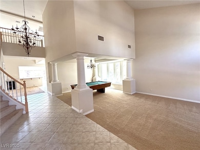 Rec room with a chandelier, a high ceiling, decora