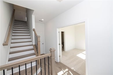 Photos not of actual home but a similar unit built previously. Staircase featuring wood finished floors and recessed lighting