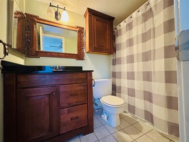 Full bathroom with a shower with curtain, light tile patterned floors, vanity, and a textured ceiling