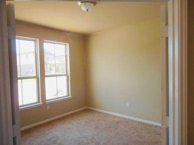 Carpeted empty room featuring baseboards