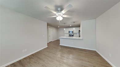 Unfurnished living room featuring light wood-style flooring and ceiling fan