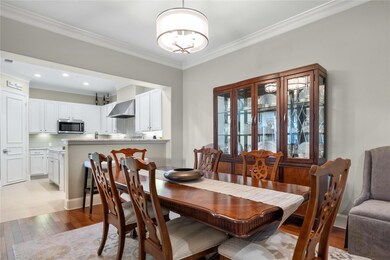 Dining space with crown molding, an inviting chand