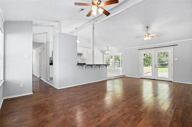 Unfurnished living room featuring a ceiling fan, d