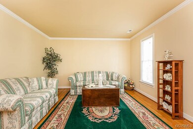 Formal living room with hardwood floors and crown