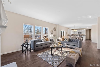 Living room featuring dark wood-style flooring and a chandelier