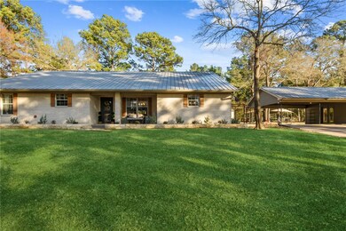 Rear view of house with a lawn and a carport