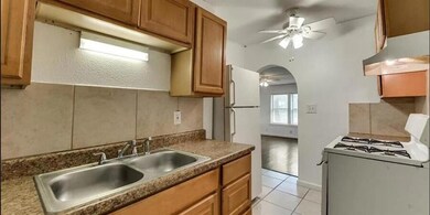 Kitchen with white appliances, sink, ceiling fan, 
