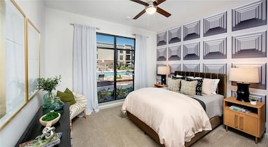 Carpeted bedroom featuring ceiling fan